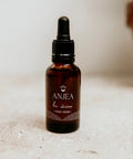 Huile visage et corps Anjea La Divine Éclat visage, bouteille avec pipette, texture huile lumineuse pour la peau.
