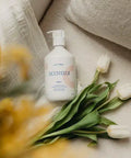 Lait pour le corps Minois Paris, hydratation douce pour visage et corps, flacon blanc avec pompe, texture onctueuse et apaisante.