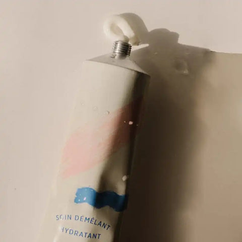 Soin démêlant Minois Paris pour démêlage et hydratation, bouteille avec étiquette verte et liquide transparent